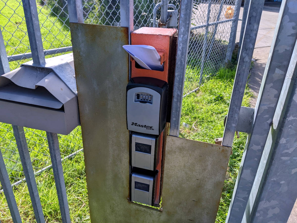 Range of letter boxes and key boxes on a gate